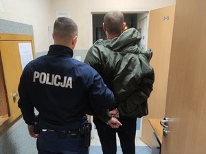 Zdjęcie przedstawia umundurowanego policjanta wraz z zatrzymanym mężczyzną.