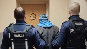 Zdjęcie przedstawia: dwóch umundurowanych policjantów z zatrzymanym mężczyzną.