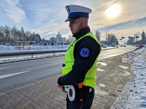 Zdjęcie przedstawia: policjanta ruchu drogowego przy drodze.