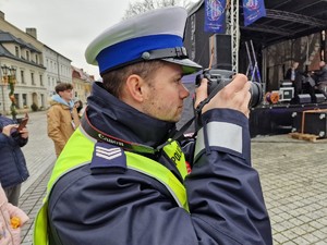 Zdjęcie przedstawia: policjanta podczas robienia zdjęć.