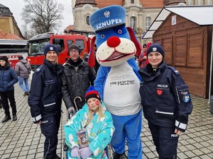 Zdjęcie przedstawia: policjantki, Sznupka, mężczyznę i dziewczynkę na wózku inwalidzkim.
