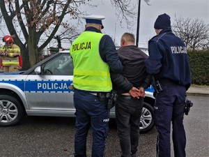 Zdjęcie przedstawia: dwóch umundurowanych policjantów z zatrzymanym mężczyzną.