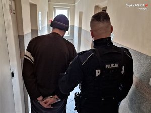 Zdjęcie przedstawia umundurowanego policjanta z zatrzymanym mężczyzną.