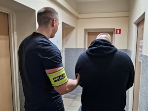 Zdjęcie przedstawia policjanta z zatrzymanym mężczyzną.