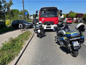 Zdjęcie przedstawia: dwa policyjne motocykle, wóz straży pożarnej i samochód osobowy.