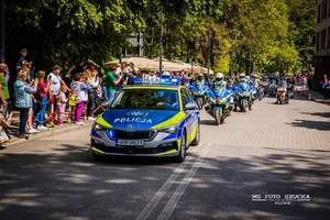 Zdjęcie przedstawia: policyjny radiowóz, za nim policyjne i cywilne motocykle.