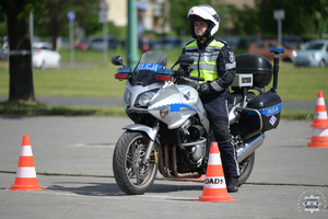 Zdjęcie przedstawia: policjanta na policyjnym motocyklu.