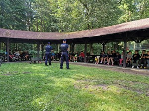 Zdjęcie przedstawia: dwóch umundurowanych policjantów przed grupą dzieci.