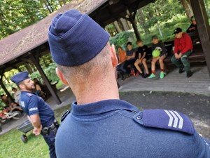 Zdjęcie przedstawia: policjantów podczas pogadanki z dziećmi.