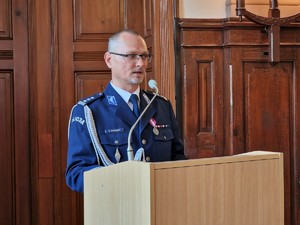 Zdjęcie przedstawia: policjanta podczas przemówienia.