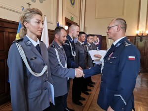 Zdjęcie przedstawia: policjantów podczas składania gratulacji.