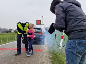 Zdjęcie przedstawia scenę z planu, policjant idzie z dziewczynką.