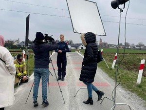 Zdjęcie przedstawia scenę z planu, przed kamerą stoi umundurowana policjantka.