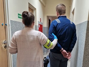 Zdjęcie przedstawia policjantkę z zatrzymanym mężczyzną.