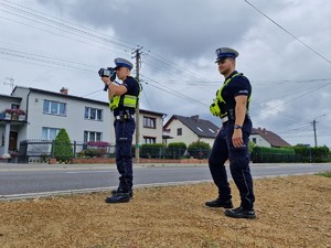 Zdjęcie przedstawia: dwóch policjantów ruchu drogowego podczas czynności służbowych.