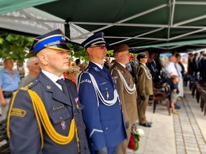 Zdjęcie przedstawia mundurowych. Wśród nich przedstawiciel straży pożarnej, Policji i żołnierz.