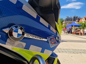 Zdjęcie przedstawia policyjny motocykl na płycie rynku.