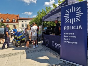 Zdjęcie przedstawia policjantów na stanowisku informacyjno-profilaktycznym.