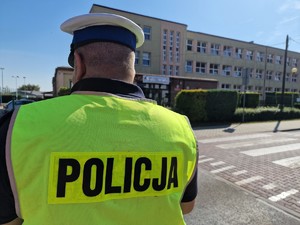 Zdjęcie przedstawia umundurowanego policjanta ruchu drogowego przy przejściu dla pieszych.