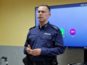 Zdjęcie przedstawia: 
Mówiącego umundurowanego policjanta.