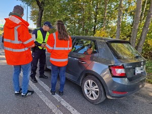 Zdjęcie przedstawia:  
Funkcjonariusza policji pochylającego się nad kierowcą oraz dwóch przedstawicieli Kolei Śląskich.