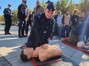 Na zdjęciu umundurowana policjantka ćwicząca prowadzenie resuscytację na fantomie