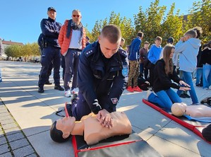 Na zdjęciu umundurowany policjant ćwiczący prowadzenie resuscytację na fantomie