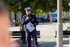 Na zdjęciu przemawiający umundurowany policjant