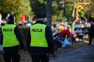 Dwóch umundurowanych policjantów na cmentarzu