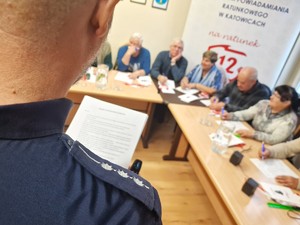 Zdjęcie przedstawia: pagony policjanta, dalej widoczni seniorzy.