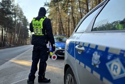 zdjęcie przedstawia policjanta obserwującego ruch pojazdów
