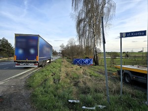 Zdjęcie przedstawia: tył TIRa oraz zasłonięty pojazd osobowy widziane z ulicy Krótkiej