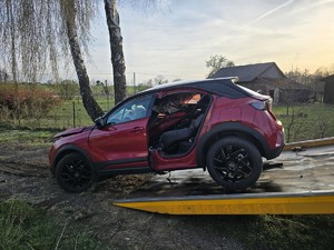Zdjęcie przedstawia: pojazd osobowy widziany z lewej strony wciągany na lawetę