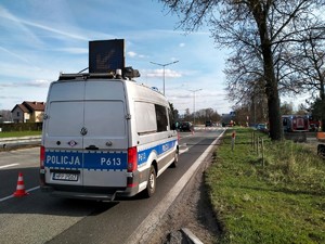 Zdjęcie przedstawia: wóz policyjny kierujący ruchem oraz wóz straży pożarnej