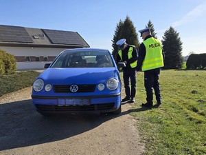 Zdjęcie przedstawia: funkcjonariusza policji zapisującego dane kierowcy
