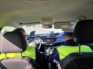 Zdjęcie przedstawia: dwóch funkcjonariuszy policji w radiowozie