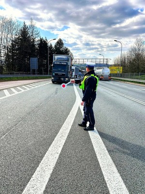 Zdjęcie przedstawia: funkcjonariusza policji kierującego ruchem