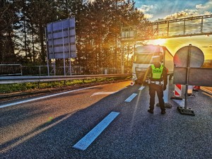 Zdjęcie przedstawia: funkcjonariusza policji wskazującego kierunek jazdy