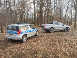 Zdjęcie przedstawia: dwa samochody stojące w lesie.