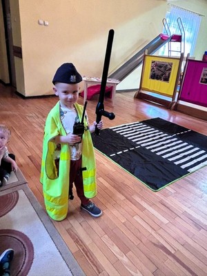 Zdjęcie przedstawia: chłopczyka z akcesoriami policyjnymi.