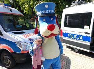 Zdjęcie przedstawia: uczestnika wydarzenia wraz z maskotką.