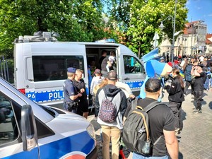 Zdjęcie przedstawia: wielu uczestników oglądających radiowóz policyjny.