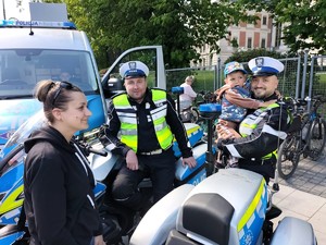 Zdjęcie przedstawia: dwóch umundurowanych policjantów wraz z uczestnikami wydarzenia.