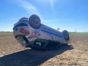 Zdjęcie przedstawia: odwrócone auto leżące na dachu.