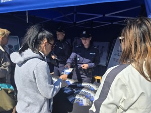 Zdjęcie przedstawia: policjantkę rozdającą ulotki.