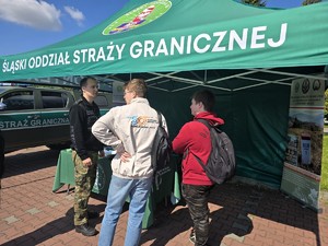 Zdjęcie przedstawia:  ludzi pod namiotem straży granicznej.