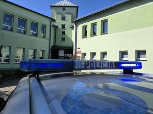 Zdjęcie przedstawia: policyjny radiowóz pod szkołą