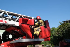 Zdjęcie przedstawia: strażak na dźwigu