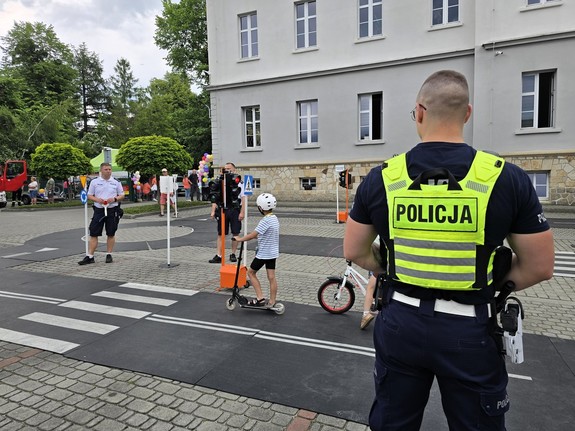Zdjęcie przedstawia:  policjantów z dziećmi w miasteczku rowerowym