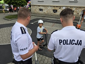 Zdjęcie przedstawia: dziecko na rowerze i dwóch policjantów